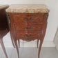 French Louis XV style wooden nightstand with marble top on a plain background