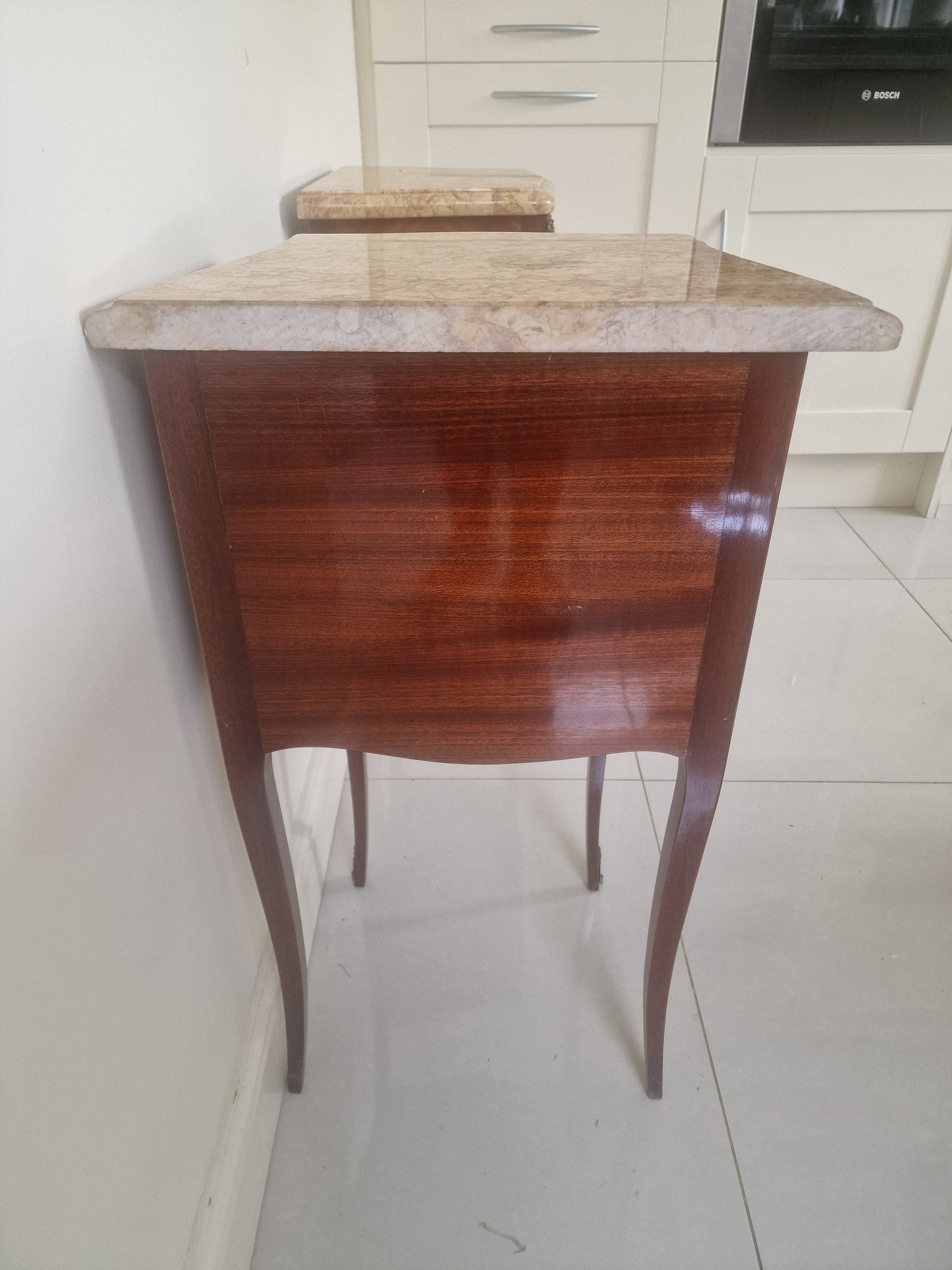 Louis XV style wooden nightstands with marble tops on a plain background