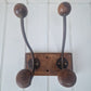 Four vintage wooden hooks on a white wall 