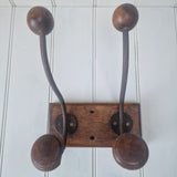 Four vintage wooden hooks on a white wall 