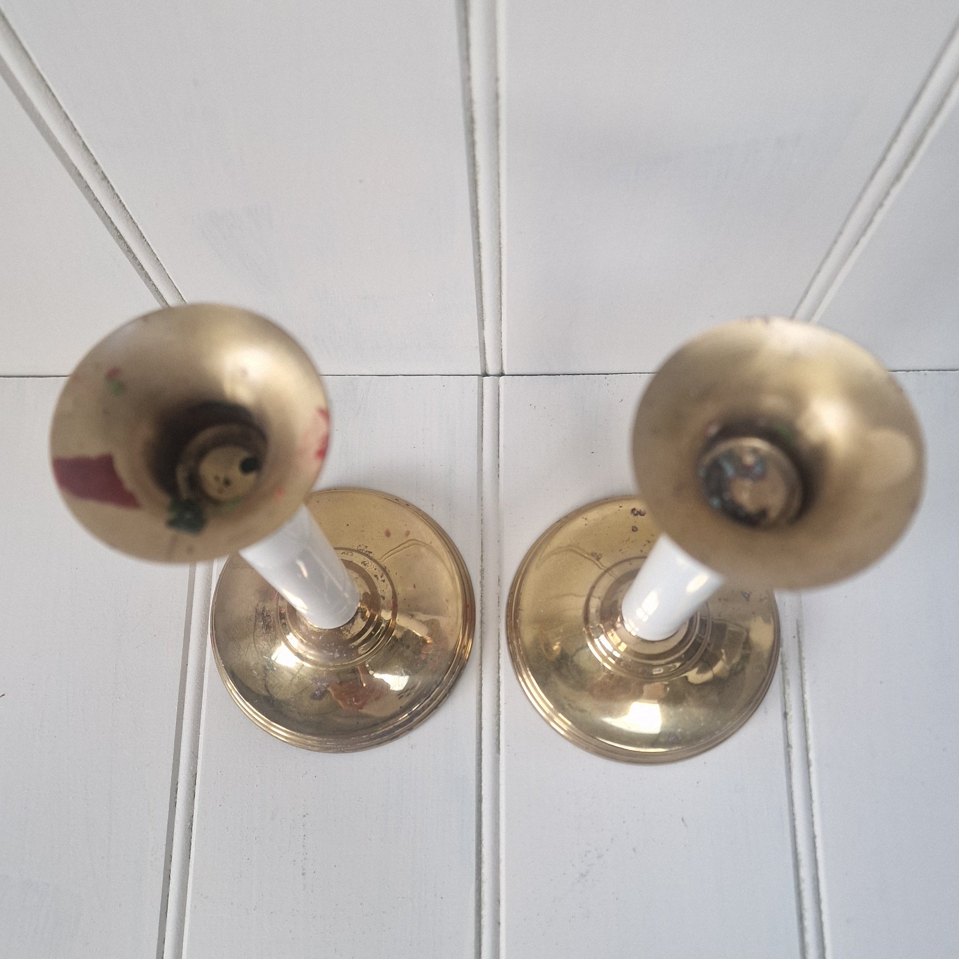 Two brass candlesticks on a panelled table