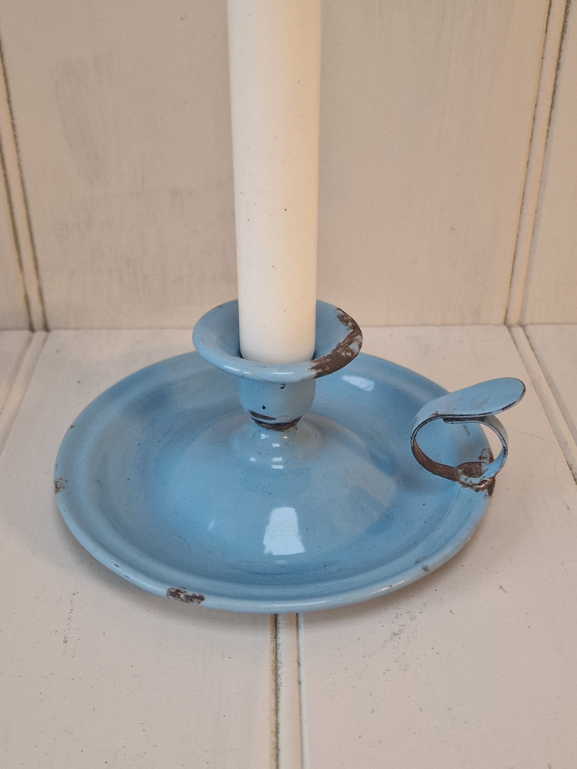 Vintage blue enamel French chamber candlestick on white table