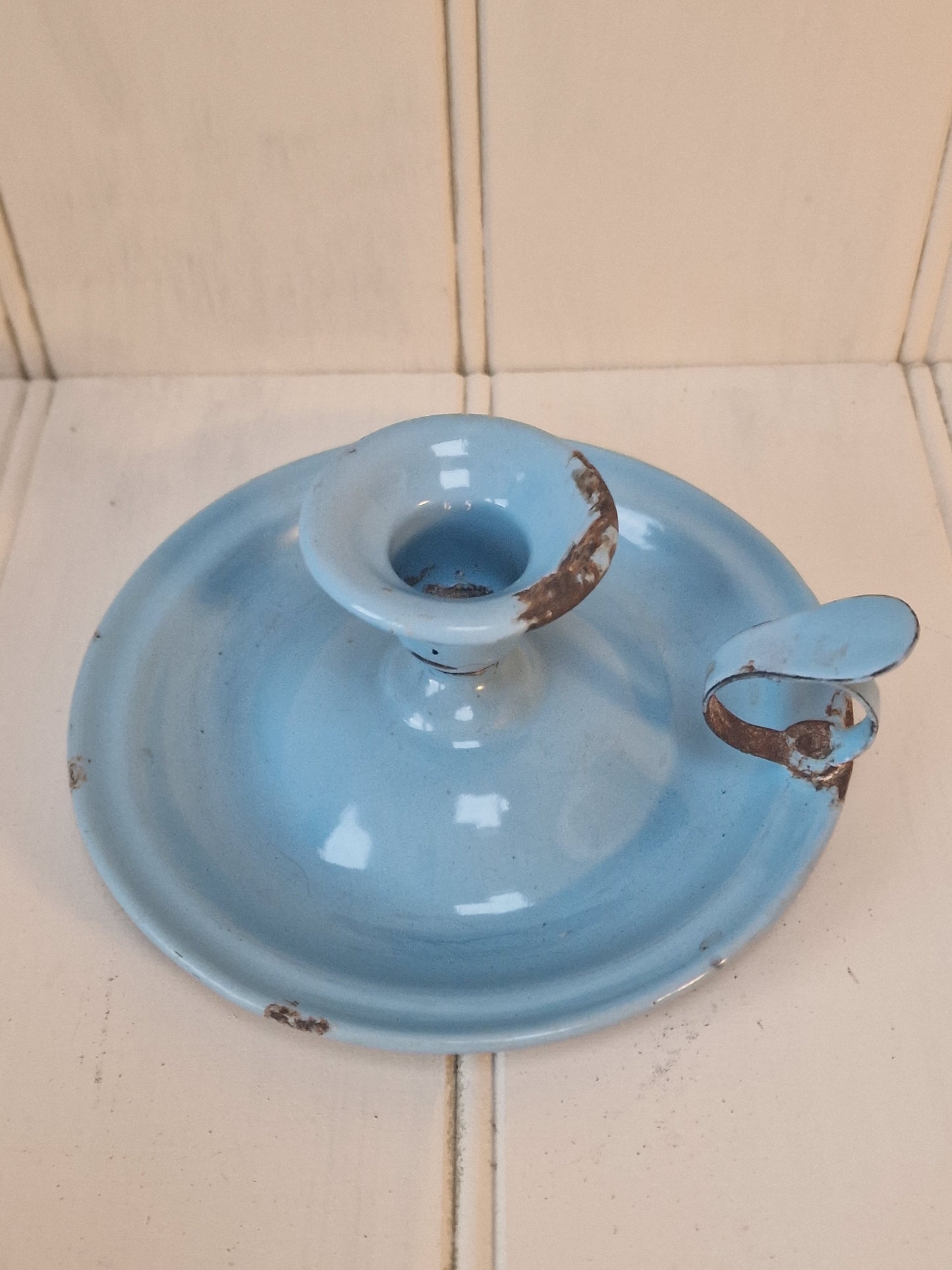 Vintage blue enamel French chamber candlestick on white table