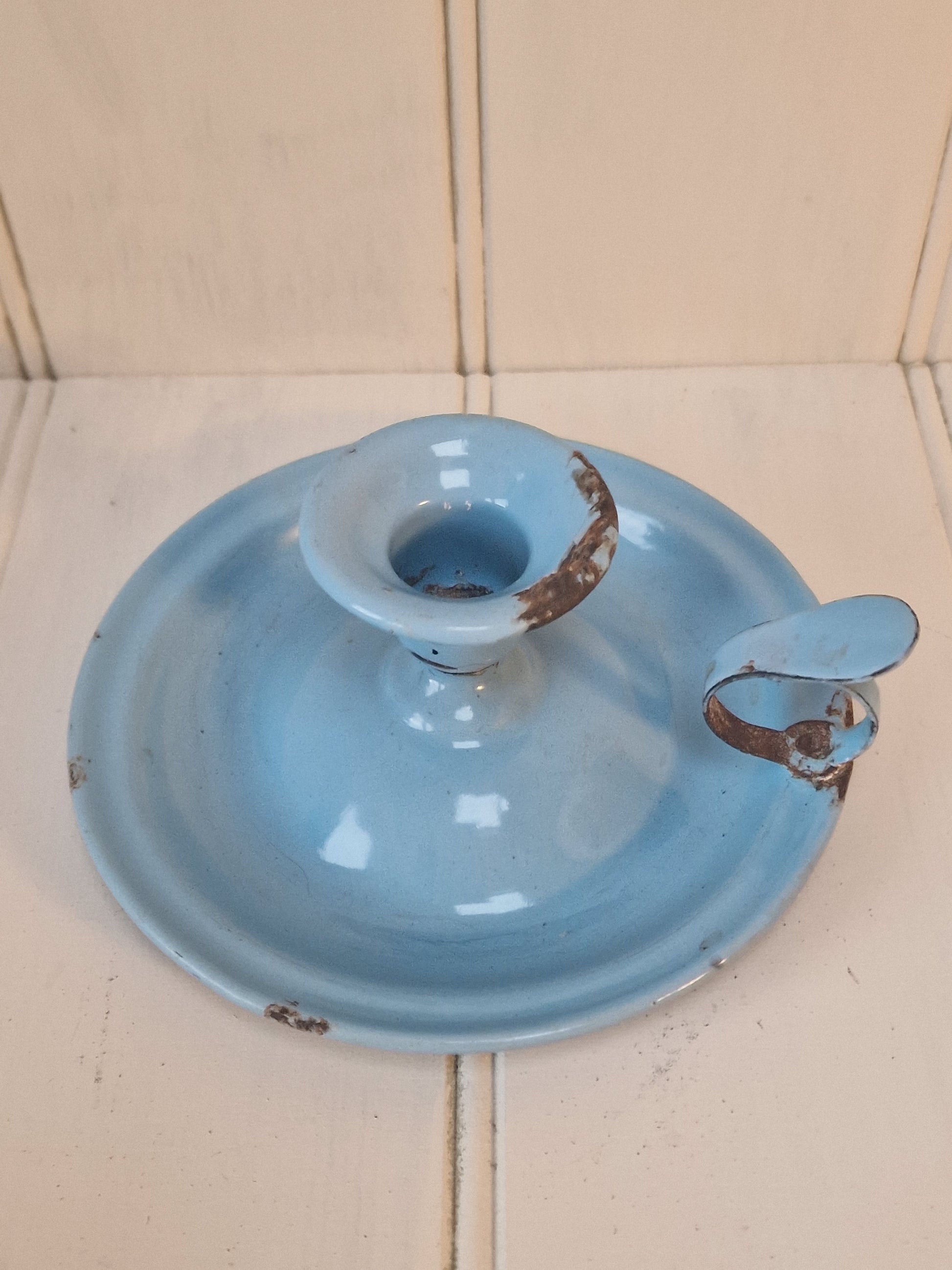 Vintage blue enamel French chamber candlestick on white table