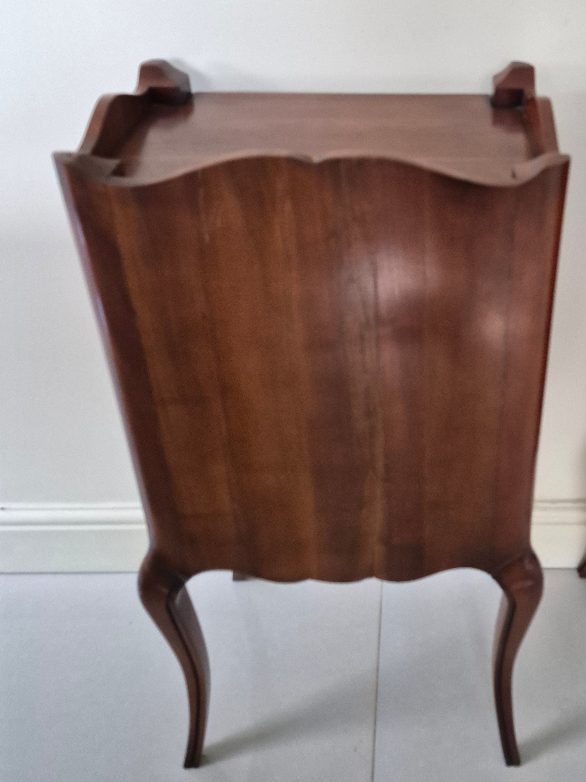 Back view of one of a pair of dark wood bedside tables 