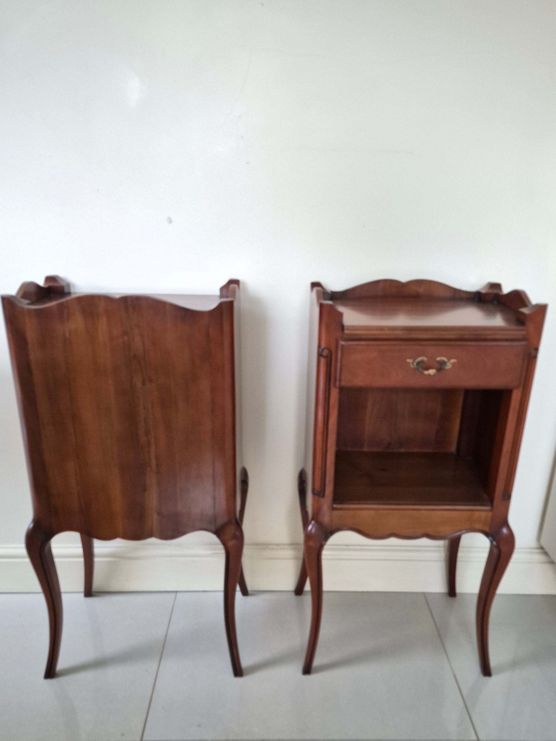 Pair of dark wood bedside tables showing the back of one table