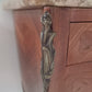 Close up of corner of French Louis XV style wooden nightstand with marble top on a plain background